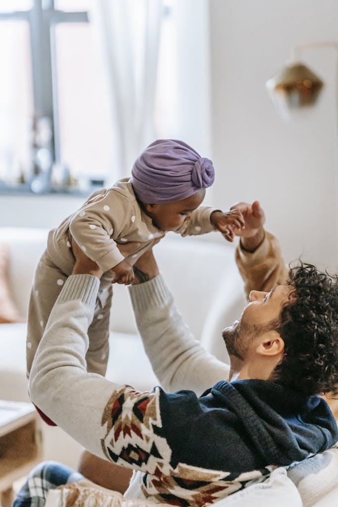 Cheerful multiracial parents playing with cute girl at home