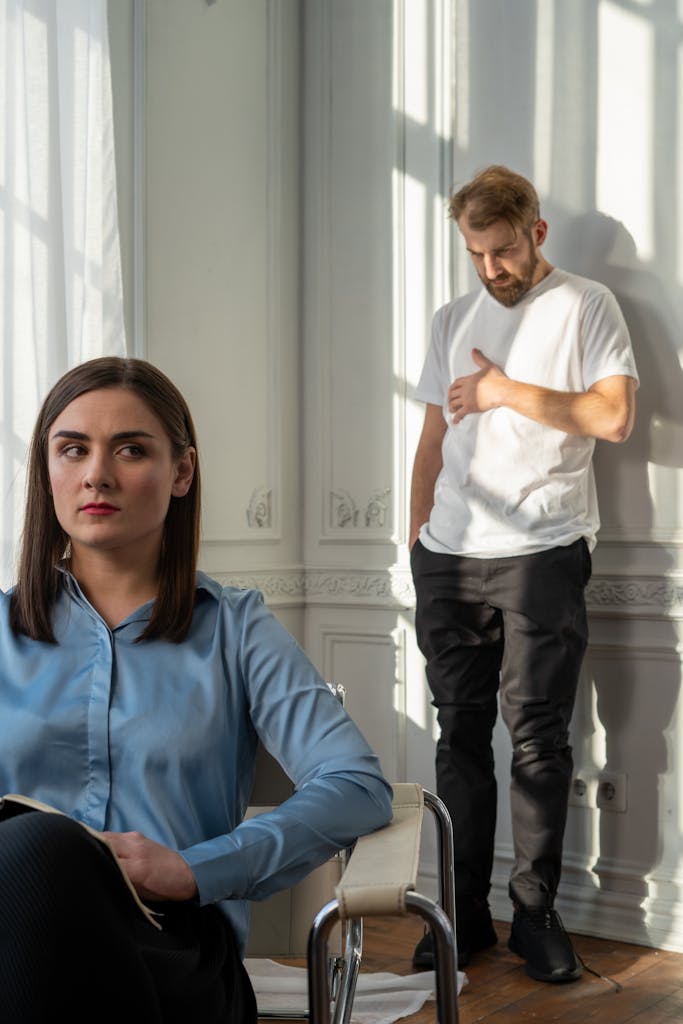 Woman in Blue Button Up Shirt Standing Beside Man in White Shirt